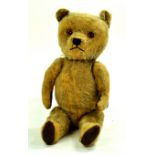 A stern looking vintage bear, well loved with age wear. Likely British Made. Enhanced Condition