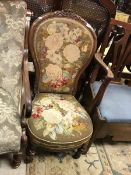 A Victorian walnut-framed spoon-back salon chair with needlework upholstery