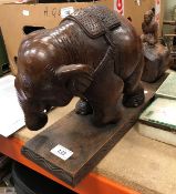 An Indian hardwood sculpture of an elephant with figure on log behind