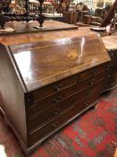A 19th Century mahogany and inlaid bureau the sloping fall opening to reveal a fitted interior and