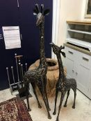 A pair of polished steel figures of giraffe and calf