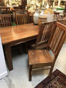 A modern Indian teak dining table and set of eight slat back dining chairs