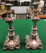 A pair of late 19th Century Russian silver table candlesticks with grape and vine decoration (bear