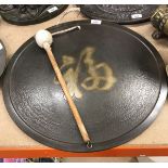 A Chinese beaten and chocolate patinated bronze gong of disc form with central script motif