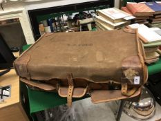 An early 20th Century Asprey leather covered suitcase with canvas outer cover bearing initials