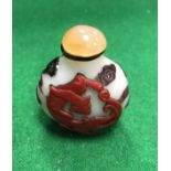 A 19th Century Chinese Peking glass snuff bottle decorated with a red dragon