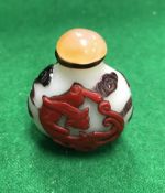 A 19th Century Chinese Peking glass snuff bottle decorated with a red dragon