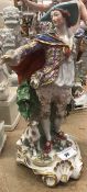 A 19th Century Continental porcelain figure of a gentleman in gilt decorated costume with dog at