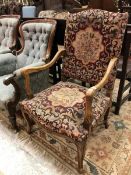 An early 20th Century Flemish-style elbow chair with needlework seats and back