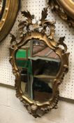 An 18th Century shaped giltwood framed wall mirror with scrolling acanthus decoration
