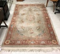 A Chinese superwash carpet, the central panel set with floral sprays on a mushroom ground,