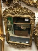 A circa 1700 carved giltwood and gesso framed wall mirror in the Rococo style