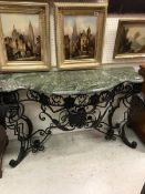A wrought iron console table in the Rococo style black painted with green marble top