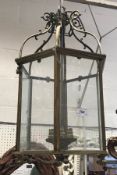 A lacquered brass-framed hexagonal glazed hanging lantern,