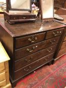 An early 19th Century oak chest of two short over three long drawers to bracket feet