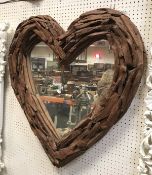 A modern heart shaped mirror with sectional teak frame