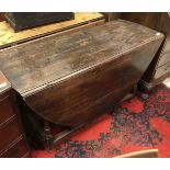 An 18th Century oak oval gate leg drop leaf dining table