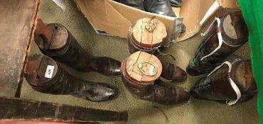 A pair of black and tan leather riding boots with wooden trees,