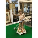 An early 20th Century Schierholz porcelain table lamp as a cherub holding aloft a torch