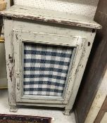 A Continental painted pine single door cupboard with wirework and fabric-covered panel as a meat