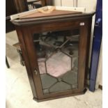 A mahogany wall-hanging corner cabinet with astragal-glazed door enclosing three shelves