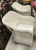 Two white painted wicker Lloyd Loom style chairs