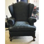 A pair of early 20th Century upholstered wing-back chairs in the Georgian manner raised on carved