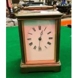 A brass cased carriage clock, the enamel dial set with Roman numerals,