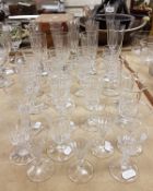 A collection of eleven various flutes and twenty-six further facet cut stemmed drinking glasses,