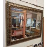 A modern rectangular wall mirror with foliate decorated frame and bevel plate together with two