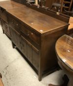 A 1930s oak sideboard in the Arts and Craft style with raised back over two drawers and two studded