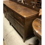 A 1930s oak sideboard in the Arts and Craft style with raised back over two drawers and two studded