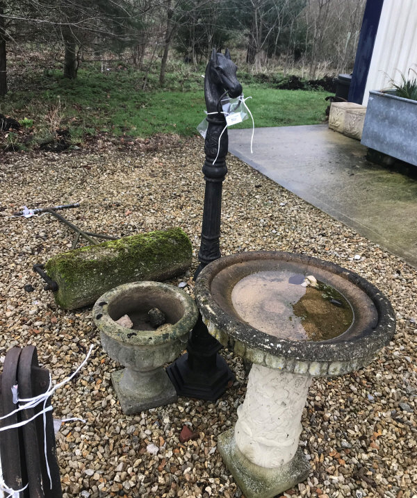 A pair of composite stone garden urns, together with a similar bird bath,