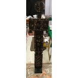 A tribal carved and painted wooden standing figure with all over geometric style decoration in red,