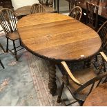 An early 20th Century oak oval draw-leaf dining table on barley-twist supports,