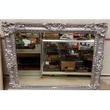 A large modern silver painted mirror with rococo style decoration and bevelled plate