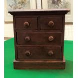 A 19th Century oak miniature chest of two short over two long drawers