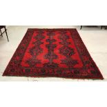 A Turkish style carpet, the repeating pattern on a red ground within a red,