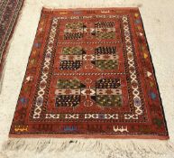 A modern Persian design rug with repeating medallion decoration on a red ground,