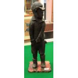 A 19th Century carved wooden figure of a young boy in cap and shorts