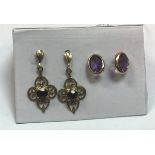 A pair of nine carat gold garnet set earrings together with a pair of nine carat gold amethyst set