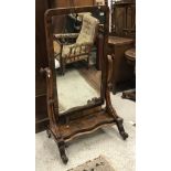 A Victorian figured mahogany-framed cheval mirror on S-scroll supports to the platform form base on