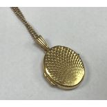 A nine carat gold locket with cut decoration and chain