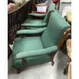 A pair of Victorian open arm chairs with green self patterned upholstery and oak frames raised on