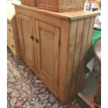 A pine two door kitchen cupboard