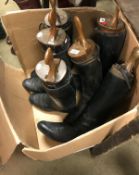 A pair of black leather riding boots with wooden trees,