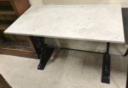 A black painted cast iron based garden table with white marble top