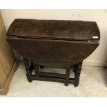 A late 17th Century oak oval gateleg drop-leaf dining table on bobbin-turned supports united by