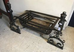 A pair of cast iron fire dogs together with cast iron fire basket