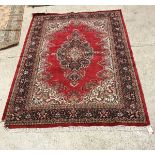 A Persian rug, the central panel set with foliate decorated medallion on a red ground,